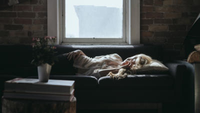 Woman laying on couch with sun shining on her face